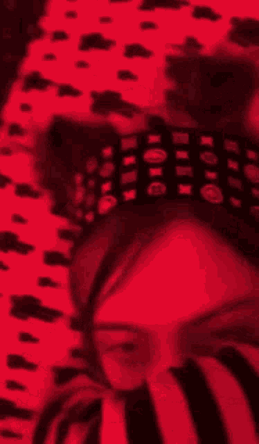 a woman in a dalmatian print shirt is smoking a cigarette in a red room