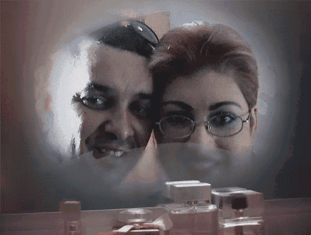 a man and a woman are looking at each other in a mirror