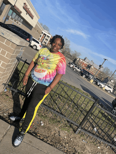 a woman wearing a tie dye t-shirt that says justice for pebbles