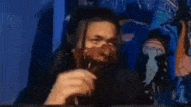 a man wearing a mask is sitting in front of a computer .