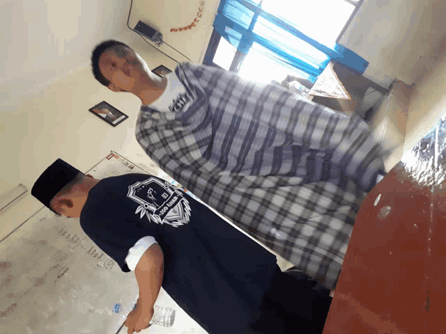 a man wearing a shirt that says ' jakarta ' on the back is standing next to another man