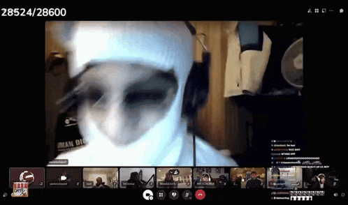 a man wearing a white mask is on a video call with other people