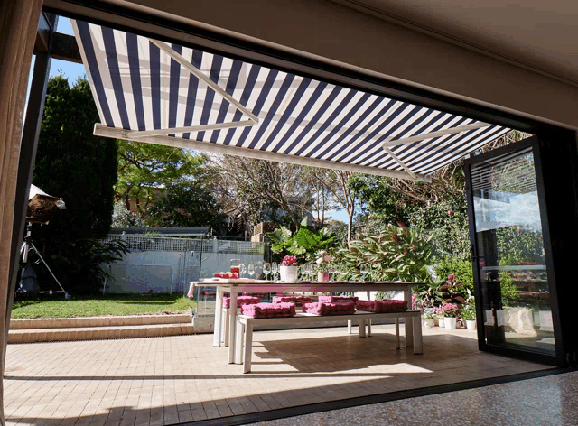 a blue and white striped awning over a table and bench