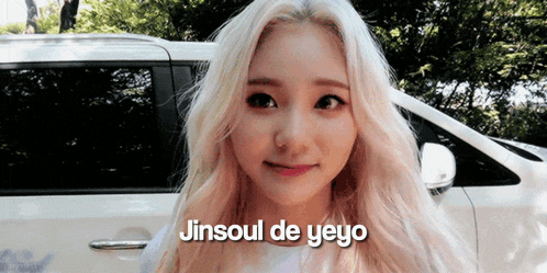 a woman with blonde hair is standing in front of a white car with the words jinsoul de yeyo written on the bottom