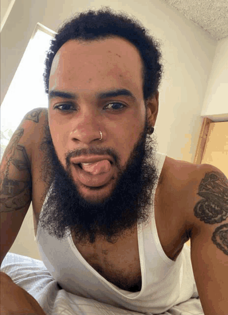 a man with a beard wearing a white tank top