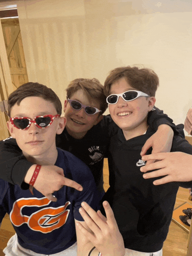 three young boys wearing sunglasses and a shirt that says nike