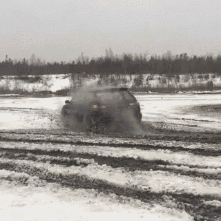 a car is drifting in the snow with smoke coming out of it