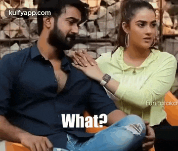 a man and a woman are sitting next to each other and the woman is holding the man 's shoulder .
