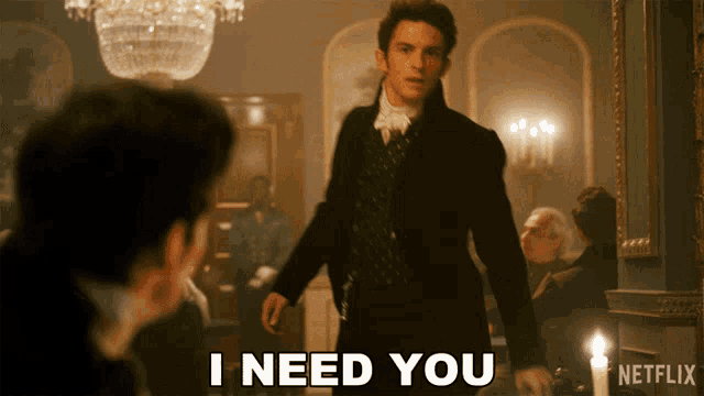 a man in a suit says " i need you " while standing in a room