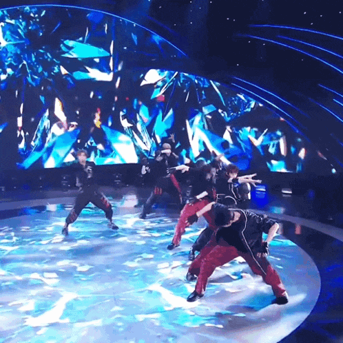 a group of people are dancing on a stage