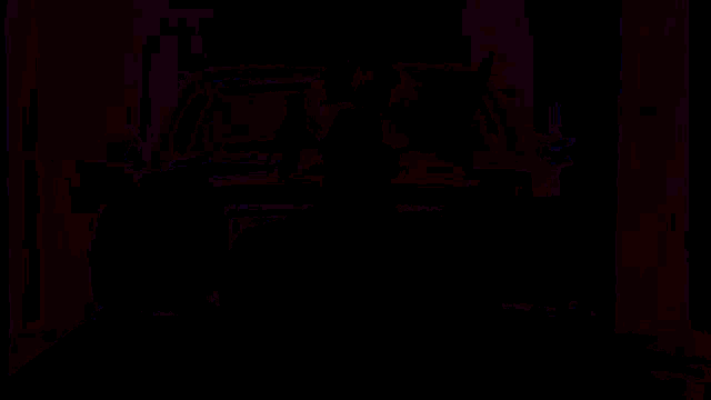 a man in a purple shirt is sitting in front of a purple car .