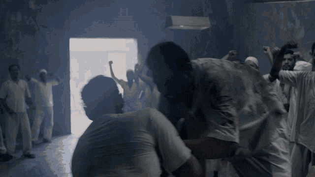 a man in a white shirt is being lifted up by another man