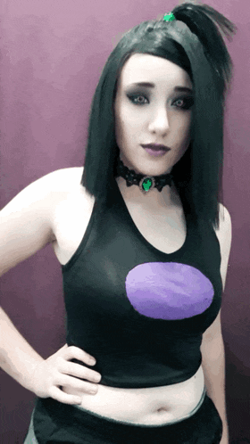a woman in a black tank top with a purple circle on the chest