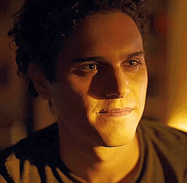 a close up of a man 's face with a dark background .