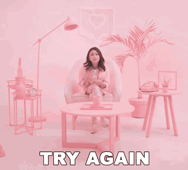a woman is sitting in a pink chair with the words try again written underneath her