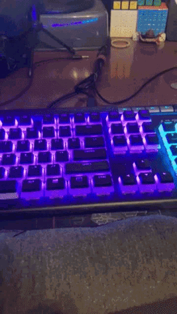 a keyboard is lit up in blue and purple with the shift key in the middle