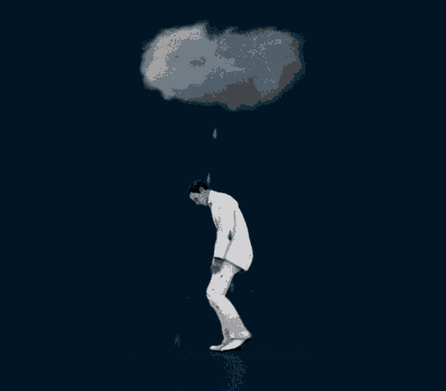 a man in a white suit walking under a cloud