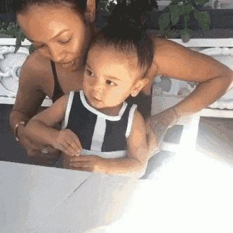 a woman is holding a little girl in her arms .