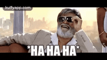 a man with a beard wearing sunglasses is laughing .