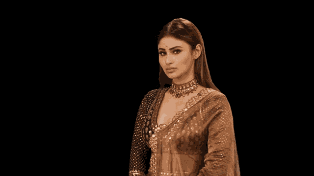 a woman wearing a necklace and a saree is making a face