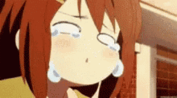a girl with red hair is crying with her eyes closed and tears running down her face .