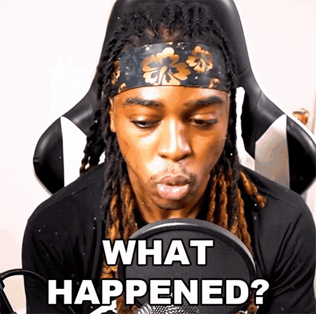 a man with dreadlocks is sitting in front of a microphone with the words what happened on the screen