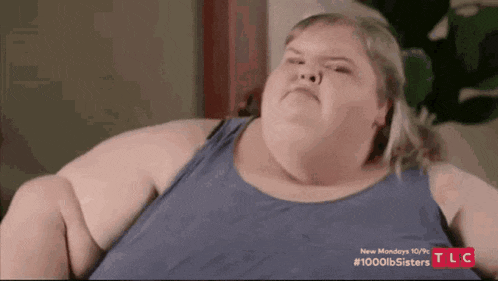 a very fat woman is sitting on a couch .