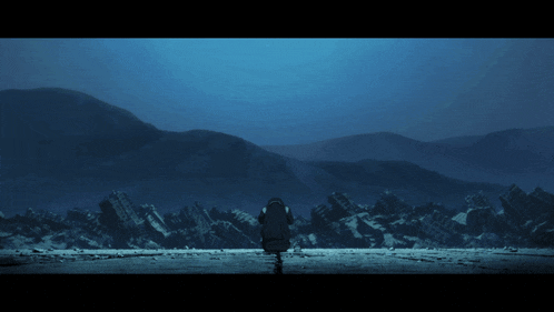 a person is standing in front of a mountain range in the dark