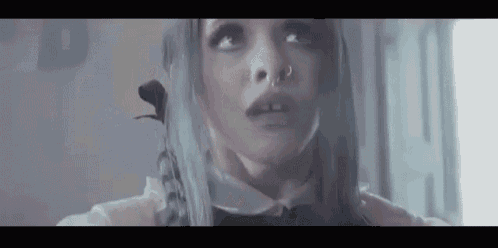 a close up of a woman 's face with a nose ring and gray hair .