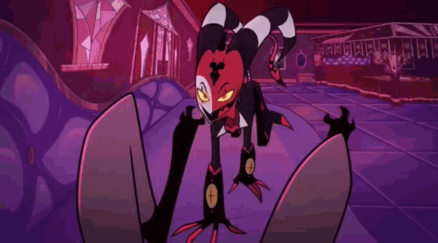 a cartoon character with horns is sitting on a purple floor in a dark room .