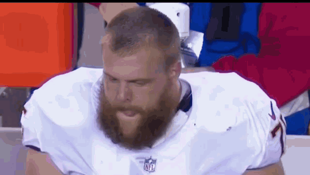a football player with a beard is wearing a white nfl jersey
