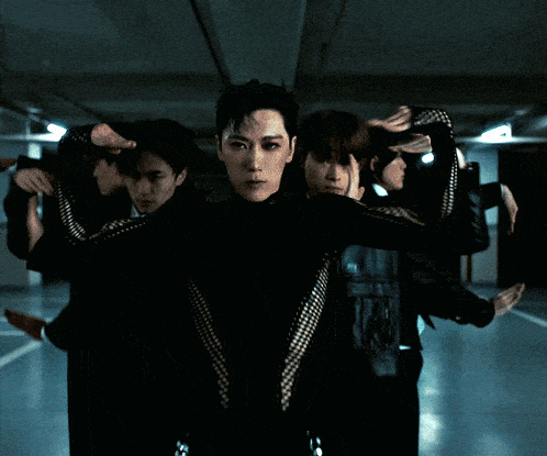 a group of people are dancing in a dark room with chains on their pants