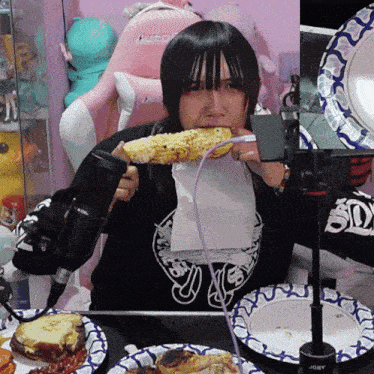 a girl eating corn on the cob with a purple cord