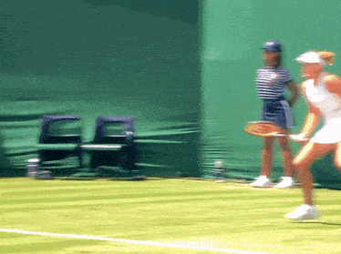 a woman holding a tennis racquet is running on a tennis court