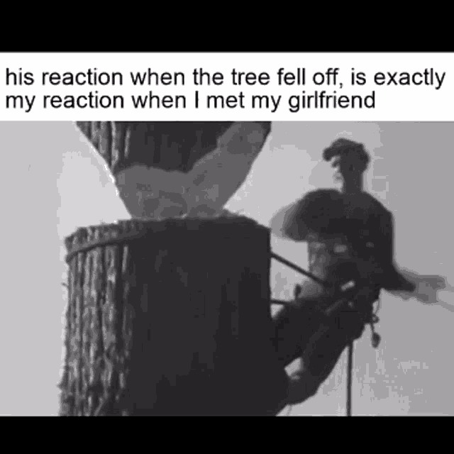 a black and white photo of a man climbing a tree trunk .