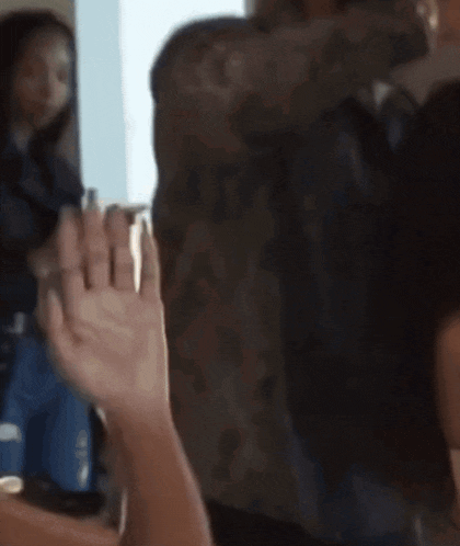 a blurry picture of a woman waving her hand in front of a window