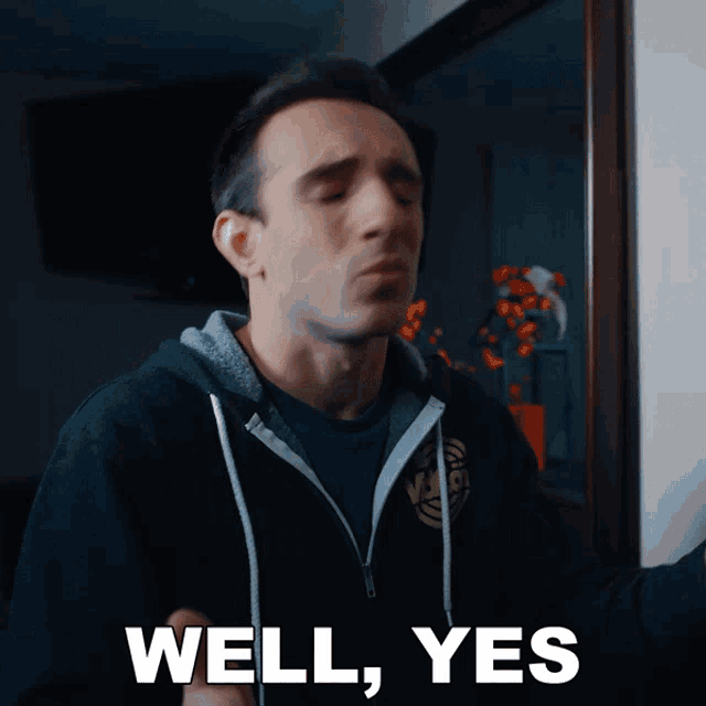 a man wearing a black hoodie says " well yes "