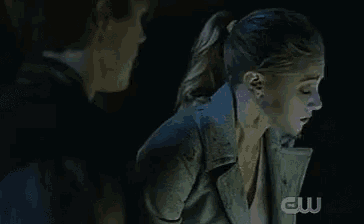 a man and woman are standing next to each other in a dark room .