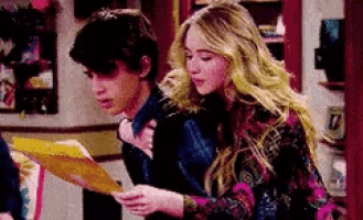 a man and a woman are looking at a piece of paper together .
