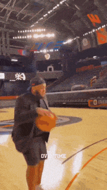 a man is holding a basketball on a basketball court with the word overtime written on the bottom