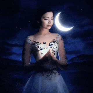 a woman in a white dress is holding a crescent moon