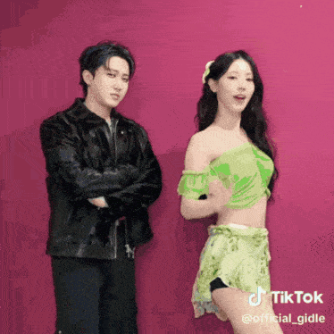 a man in a black jacket stands next to a woman in a green dress with a tiktok watermark on the bottom