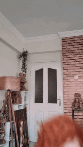 a woman with red hair is standing in a living room