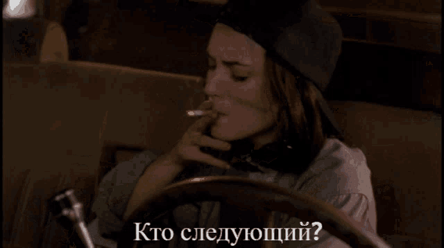 a woman sitting in a car with the words " kto следующий " written above her