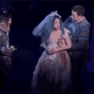 a man is riding a horse on a stage while a woman stands behind him .
