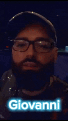 a man with a beard wearing glasses and a hat with the name giovanni on it