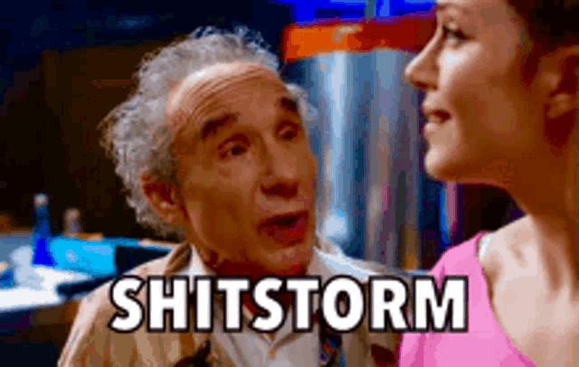 an older man and a younger woman are looking at each other and the man is saying shitstorm