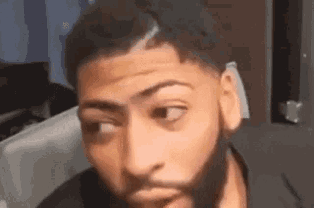 a man with a beard is making a funny face with his mouth open .