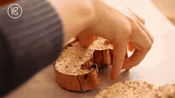 a person is cutting a cookie out of a cookie cutter shaped like a crescent moon .