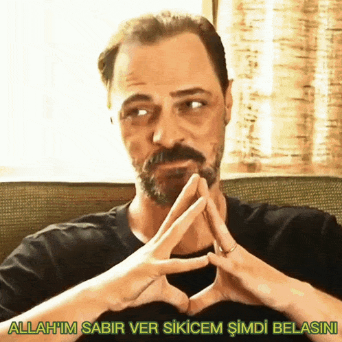 a man with a beard making a heart with his hands